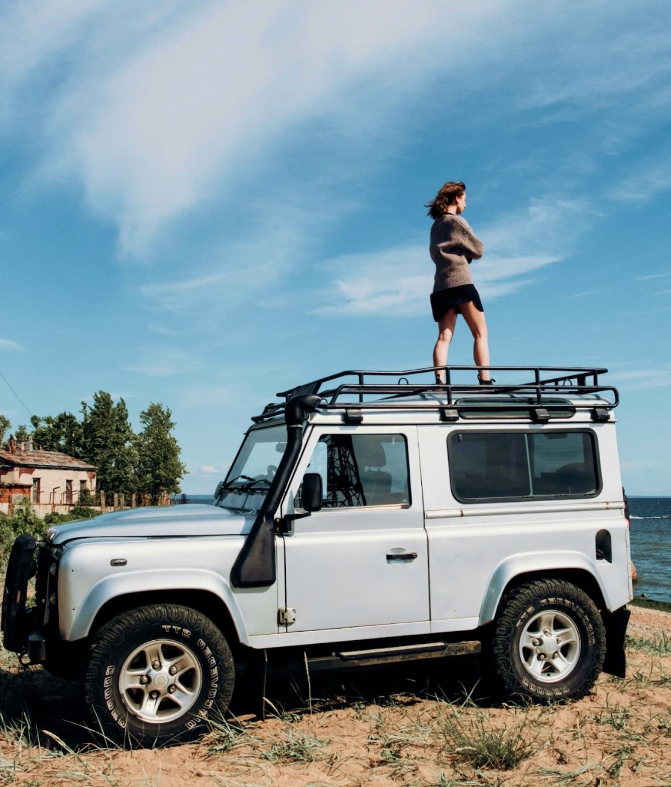 Person standing on top of a white Land Rover Defender